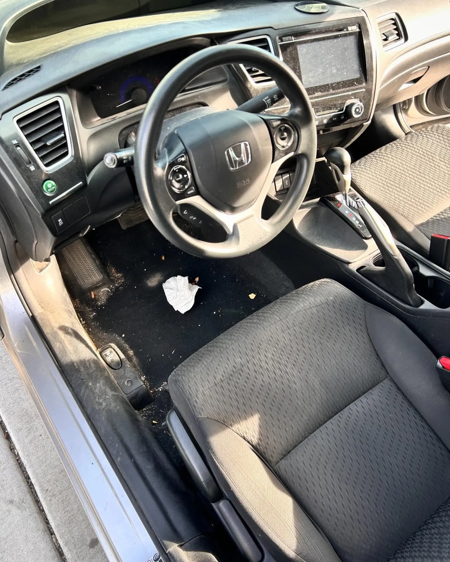 Before: the driver footwell and seat of a Honda Civic on an interior detail