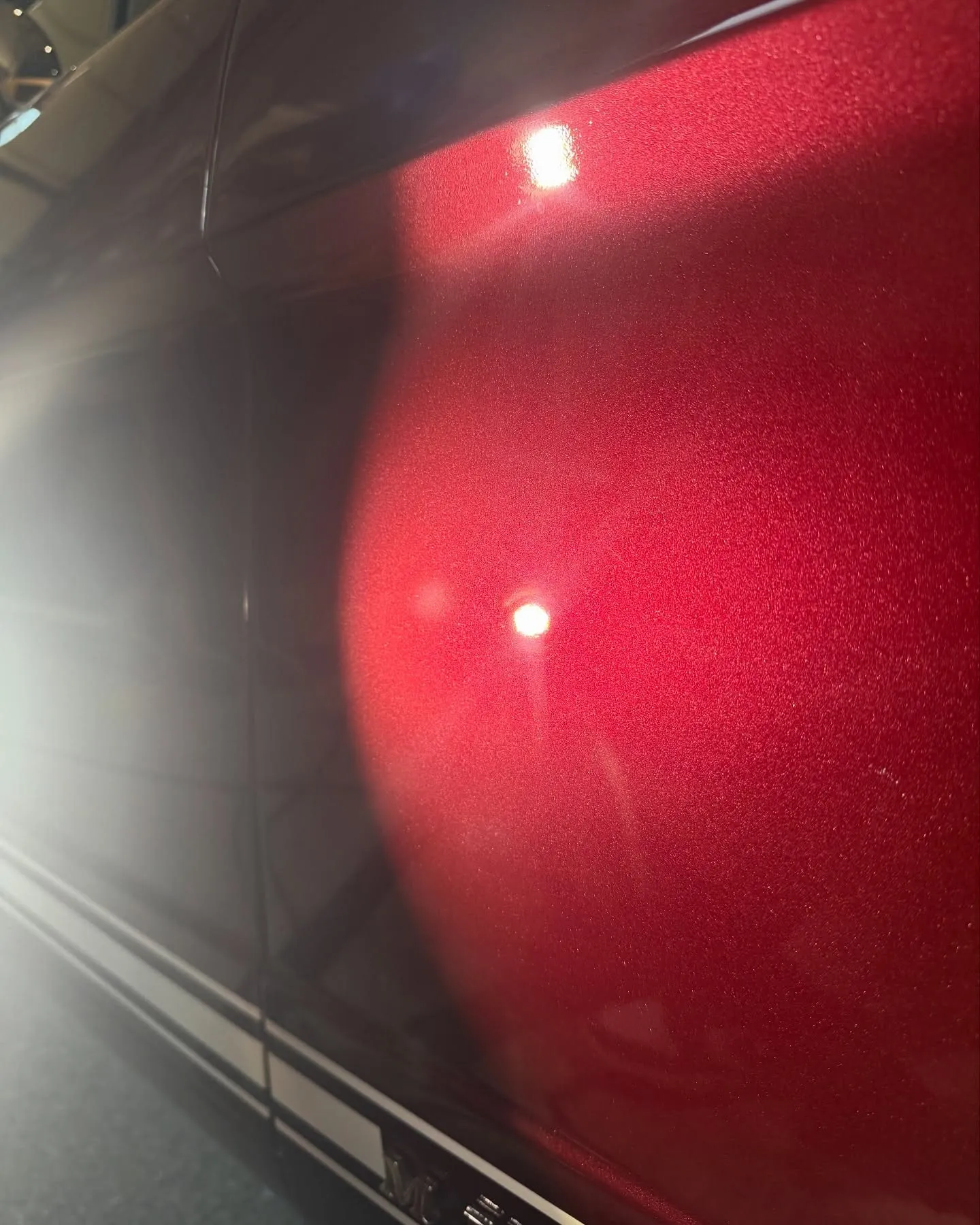 After: the fender of a maroon Mustang under a work light
