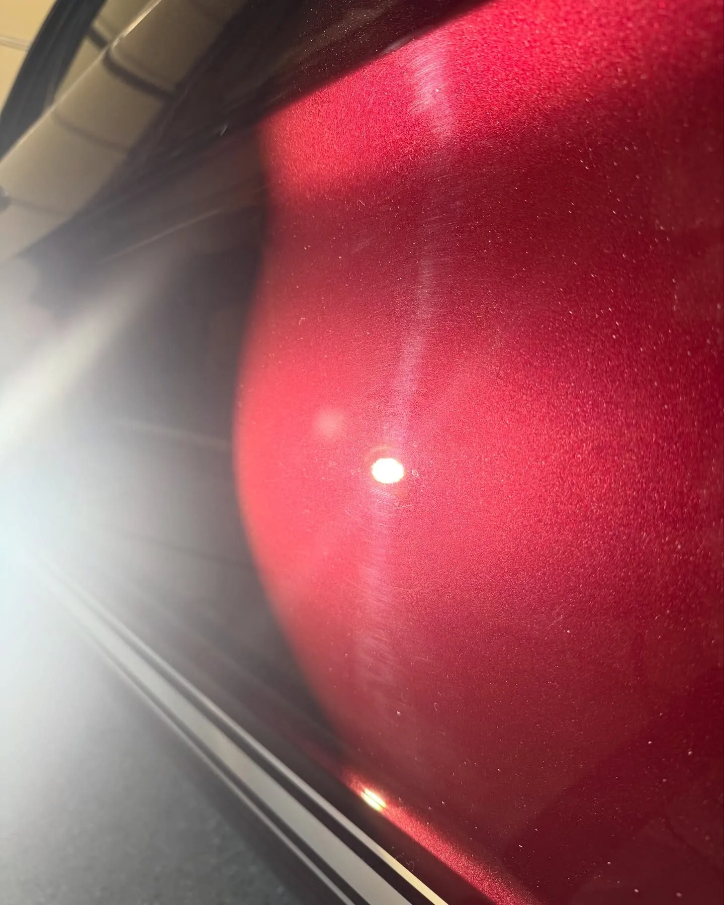 Before: the fender of a maroon Mustang under a work light