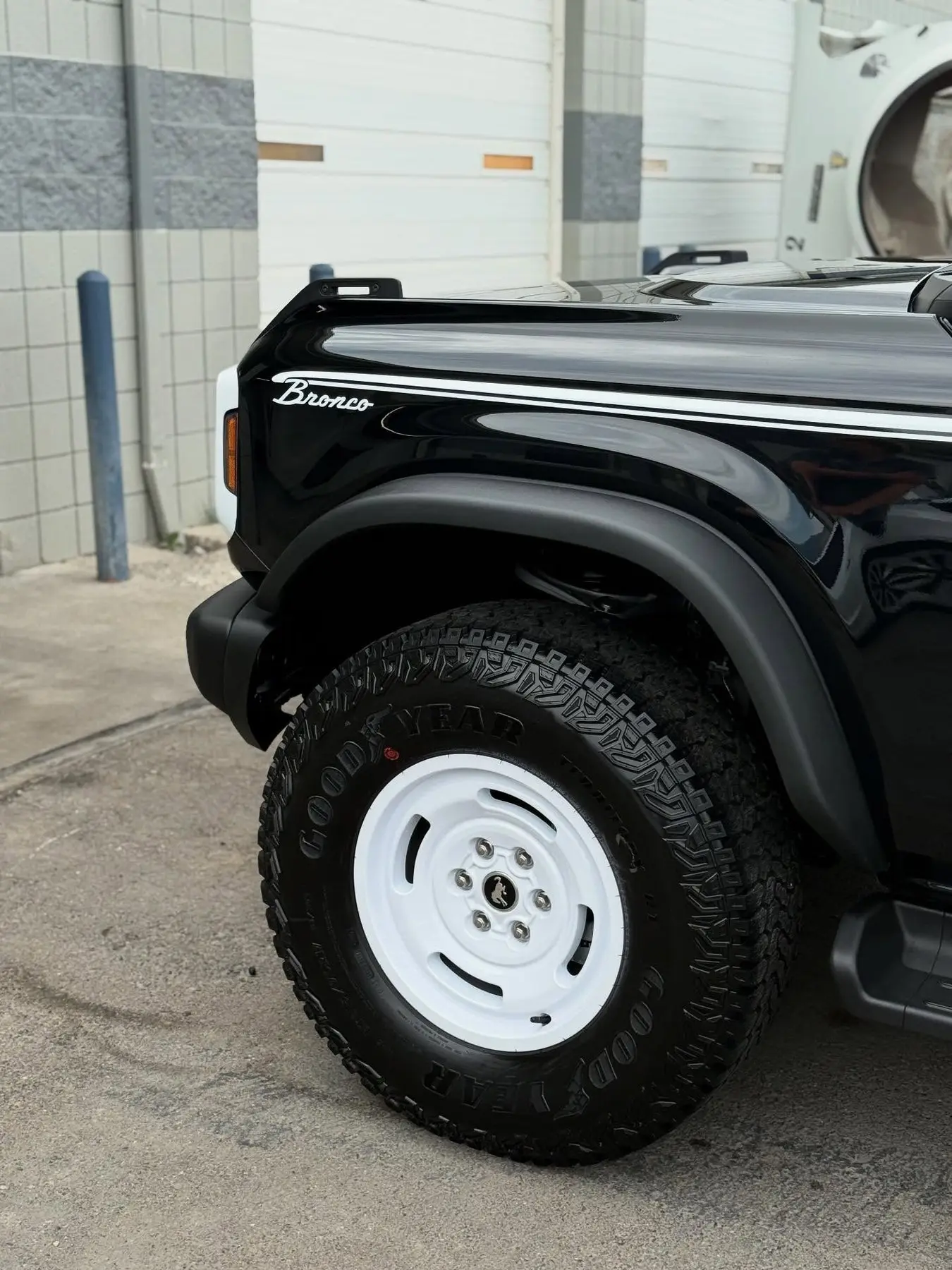 A black Ford Bronco on white steel wheels after a detail