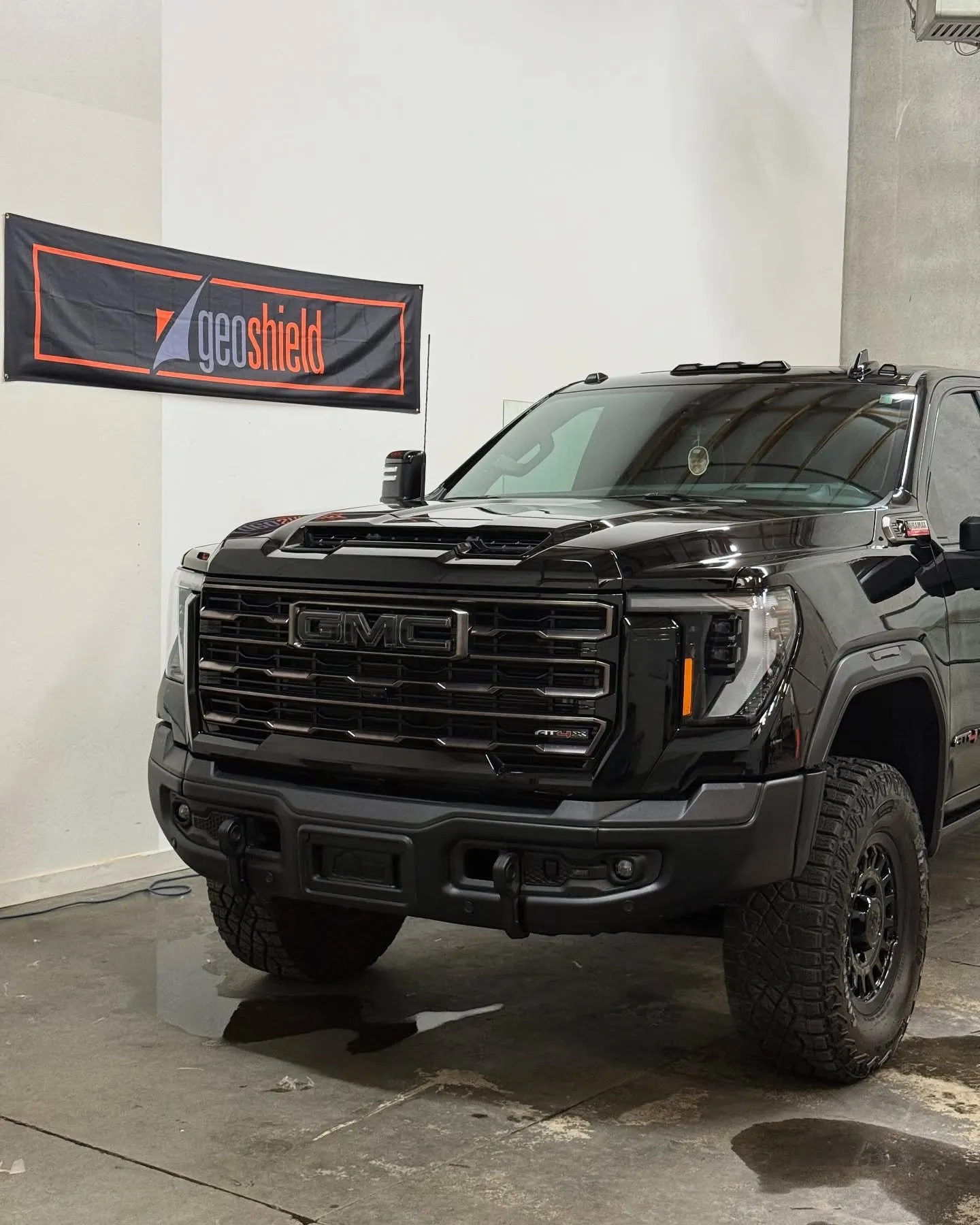 A black GMC HD truck head-on in the shop